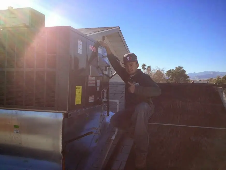 HVAC technician performing Air Duct Repair on a rooftop unit in Cornwall